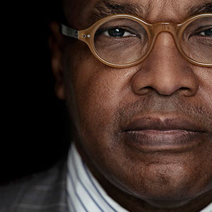 A man looking straight at the camera. It is part of a collage of 10 faces.