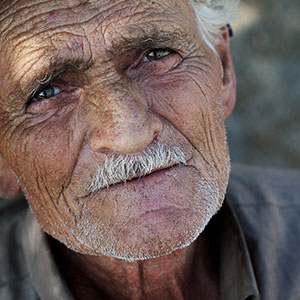 A man looking straight at the camera. It is part of a collage of 10 faces.