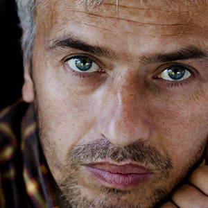 A man looking straight at the camera. It is part of a collage of 10 faces.