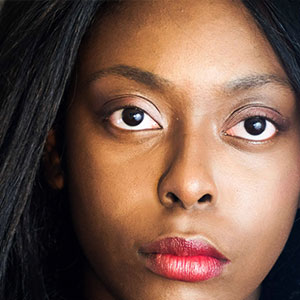 A woman looking straight at the camera. It is part of a collage of 10 faces.