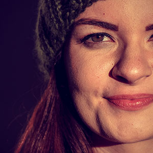 A woman looking straight at the camera. It is part of a collage of 10 faces.