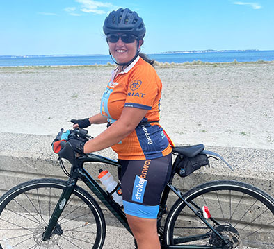 A woman bike rider in blue and orange biking gear